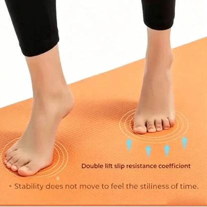 Detail van blote voeten op het oppervlak van een oranje yogamat
